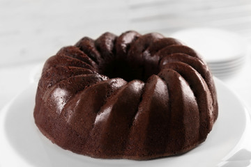 Chocolate cake on plastic mat on wooden background