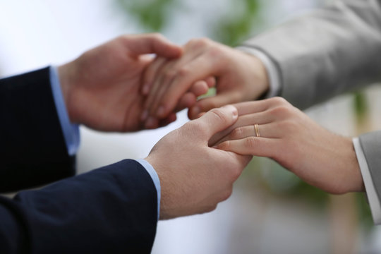 Two homosexuals holding each other hands on blurred background