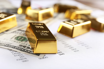 Gold bars with dollar banknotes on paper background