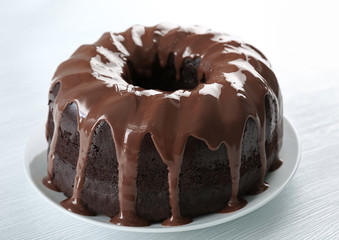 Ring chocolate cake with glaze in plate closeup