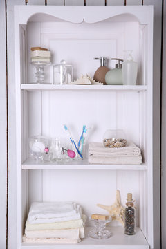 Bathroom set with towels, starfish and toothbrushes on a light shelf