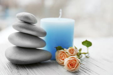 Fototapeta na wymiar Spa stones with beautiful flowers and candle on white wooden table