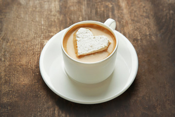 Cup of coffee with marshmallow on wooden table