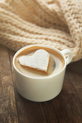 Cup of coffee with marshmallow on wooden table