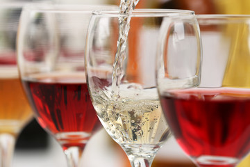 White wine pouring into glasses, closeup