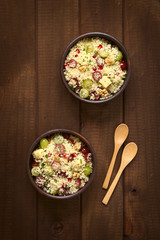 Vegetarian couscous salad with grapes, pomegranate, walnuts, cheese, lime and mint, photographed with natural light