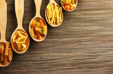 Various types of pasta in wooden spoons