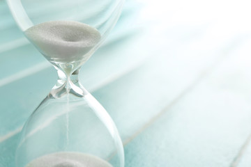 Sand hourglass on wooden background