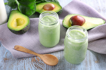 Avocado smoothie on wooden table with napkin closeup