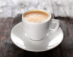 Cup of hot coffee on rustic wooden background