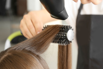 Naklejka premium Professional hairdresser drying hair