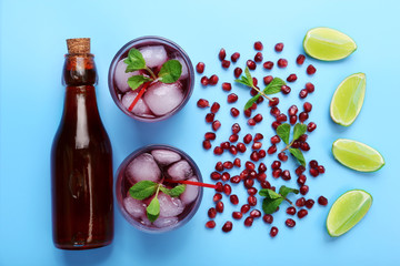 Pomegranate drink with lemon and ice cubes on blue background, top view