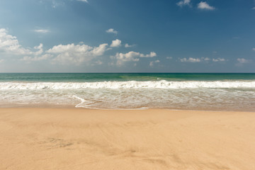 tropical beach and wave against blue sky background