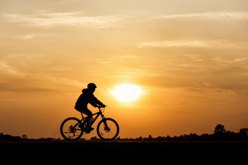 Obraz na płótnie Canvas Silhouette of cycling on sunset background