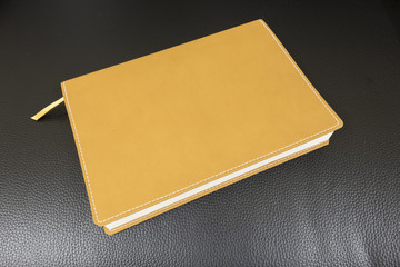 Book Yellow Leather on a Black Leather
