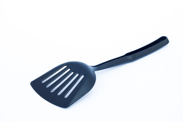 Black plastic kitchen spatula on white background