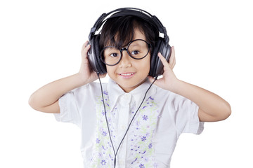 Cute girl wearing headphones in studio