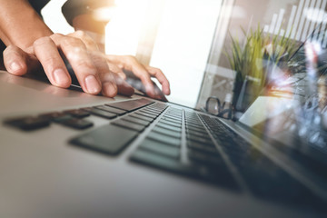 business man hand working on laptop computer with business graph