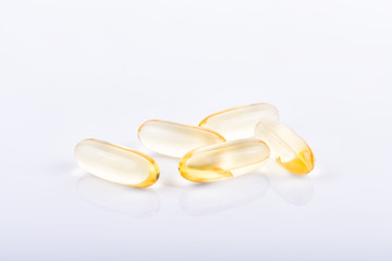 Cod liver oil omega 3 gel capsules in bowl on floor wood