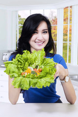 Young girl shows fresh lettuce