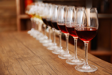 Many glasses of different wine in a row on bar counter