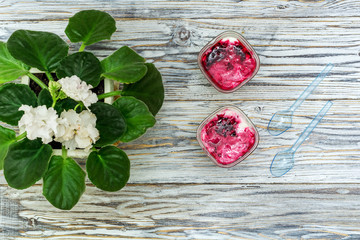 two jars of yogurt stands on the aged boards