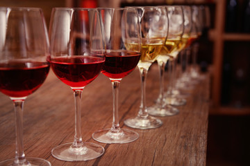 Many glasses of different wine in a row on bar counter