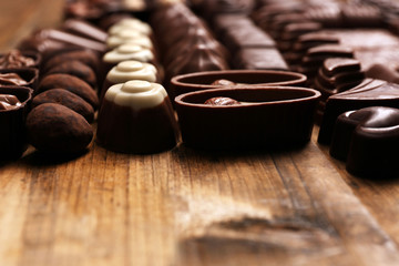 Delicious chocolate candies on wooden background