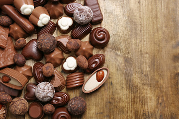 Delicious chocolate candies on wooden background