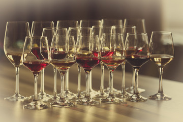 Many glasses of different wine in a row on a table