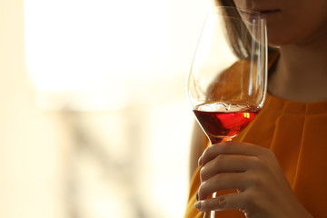 Woman sniffing red wine in a glass, close up