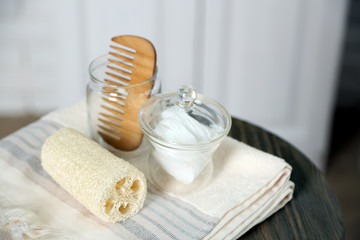 Fototapeta na wymiar Bathroom set with towels, sponges and comb on stool in light interior