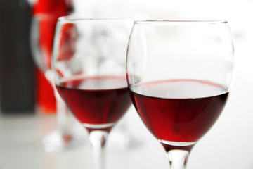 Glasses of red wine on white table closeup