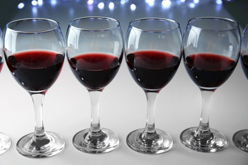 Glasses of red wine on white table closeup