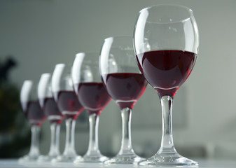 Glasses of red wine on white table closeup