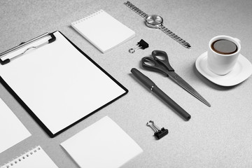 Office set with white sheets of paper, cup of coffee, watch and stationery on grey background