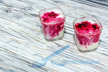 two jars of yogurt stands on the aged boards
