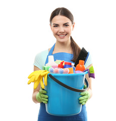 Young woman holding cleaning tools and products in bucket, isolated on white