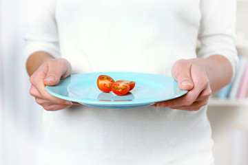 Obraz na płótnie Canvas Female hands holding a plate with sliced tomatoes.