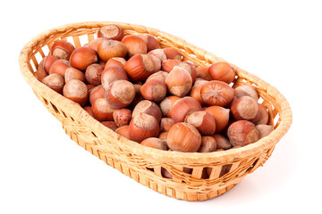 hazelnuts in a wicker basket isolated on white background