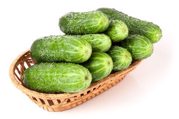 cucumbers in a wicker basket isolated on white background
