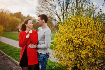 Fototapeta premium Loving couple hugging near a bush with yellow flower