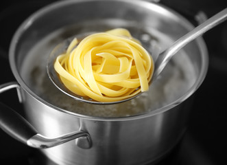 Boiling nest pasta in pan on electric stove in the kitchen