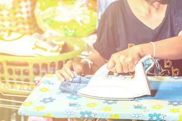 Women are sitting ironing clothes.
