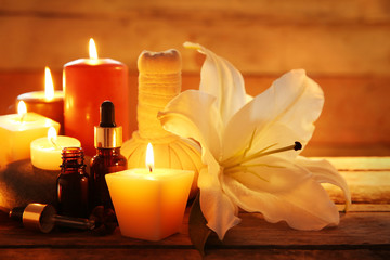 Spa set with lighted candles on wooden background