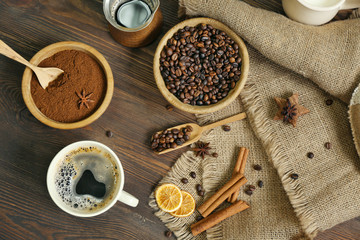Fototapeta na wymiar Coffee with beans and spices on wooden table, top view
