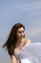 Girl holds fabric in hands waving in the wind