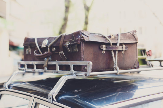 Vintage suitcase on an old car roof rack. 