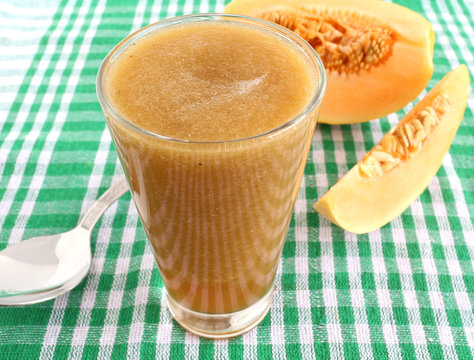 Healthy drink cantaloupe juice and slices of cantaloupe fruit.