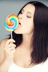 Portrait of brunette female with colored candy.
